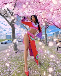 a woman in a red dress posing in front of cherry blossoms