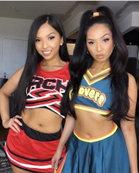 two girls in cheerleader outfits standing next to each other