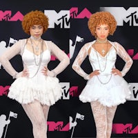 two women in white outfits on the red carpet at the mtv awards