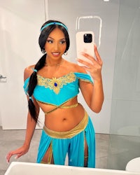 a woman in a blue jasmine costume taking a selfie